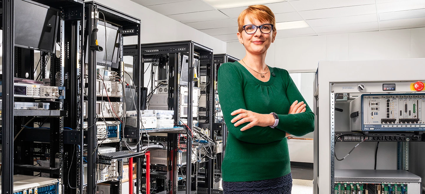 Retrato de usuario de laboratorio con racks de pruebas y equipo de pruebas en segundo plano