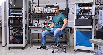 Electrical engineer surrounded by production test hardware