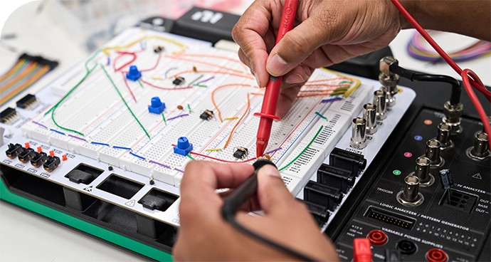 A student’s hands using the Digilent Analog Discovery Studio Max in an engineering classroom