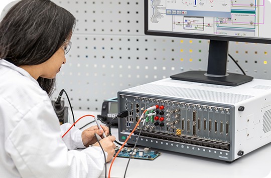 Woman in lab using probes to test a printed circuit board