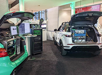 2 Electric cars with open trunks (left) NI ADAS & AD Data Record Vehicle and Jaguar Land Rover Ground Truth Data Logging Car (right) at NI Connect Munich