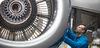 Un técnico inspecciona los componentes mecánicos de un motor de un jet comercial.
