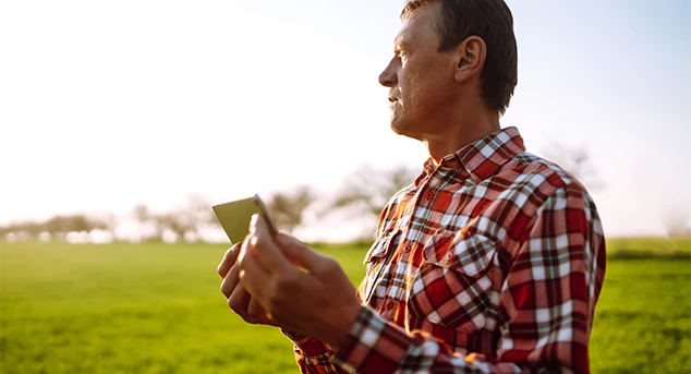 A farmer uses 5G-connected mobile devices to delegate resources