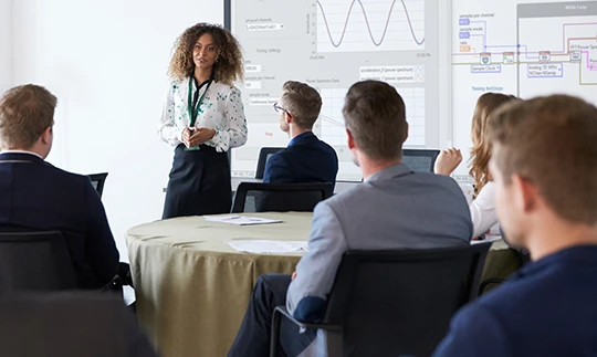 Engineers attend a seminar in a conference room