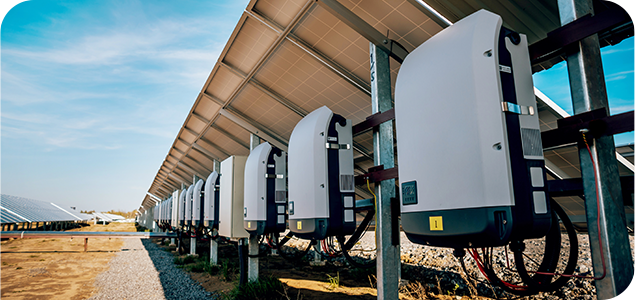 Distributed energy resource inverters installed beneath solar panels at a solar energy facility.