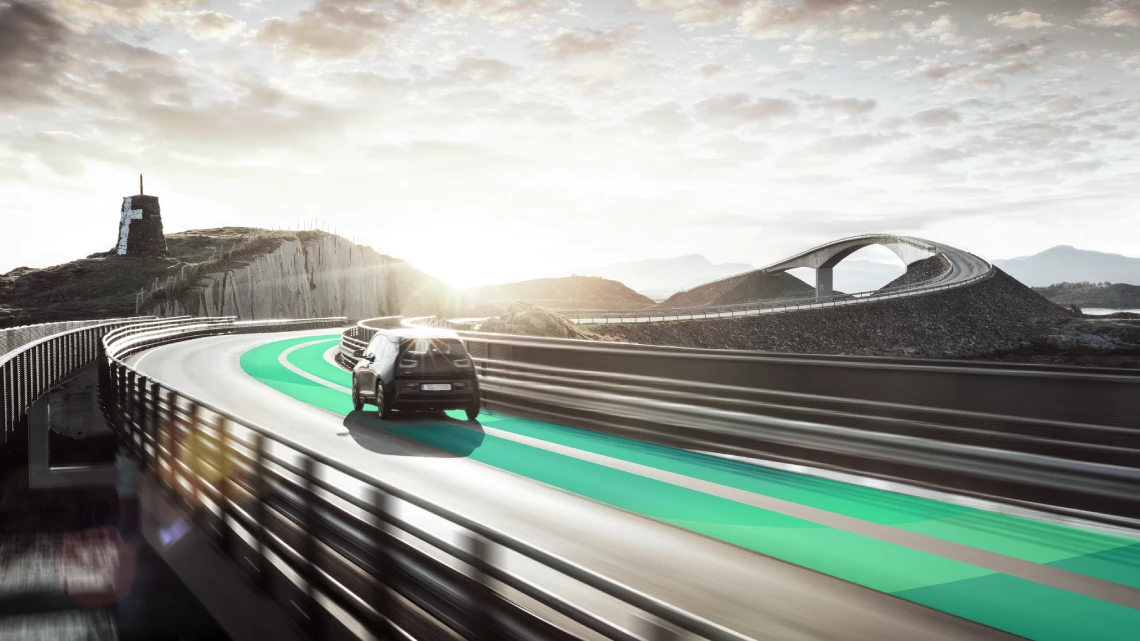 Ein Fahrzeug mit Stufenheck wird auf einer Autobahn mit Sonnenuntergang über den Hügeln einem Lärmtest beim Vorbeifahren unterzogen