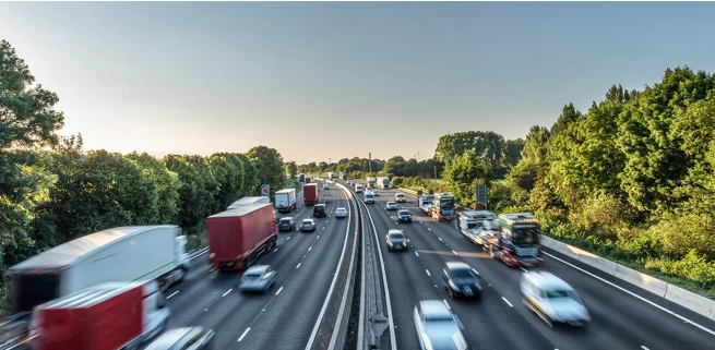 Interstate traffic with SUVs, busses, and commercial semi-trailer trucks.