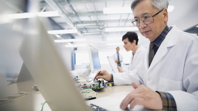 半導体テスト施設のクリーンルームでデバイスを検査するエンジニア