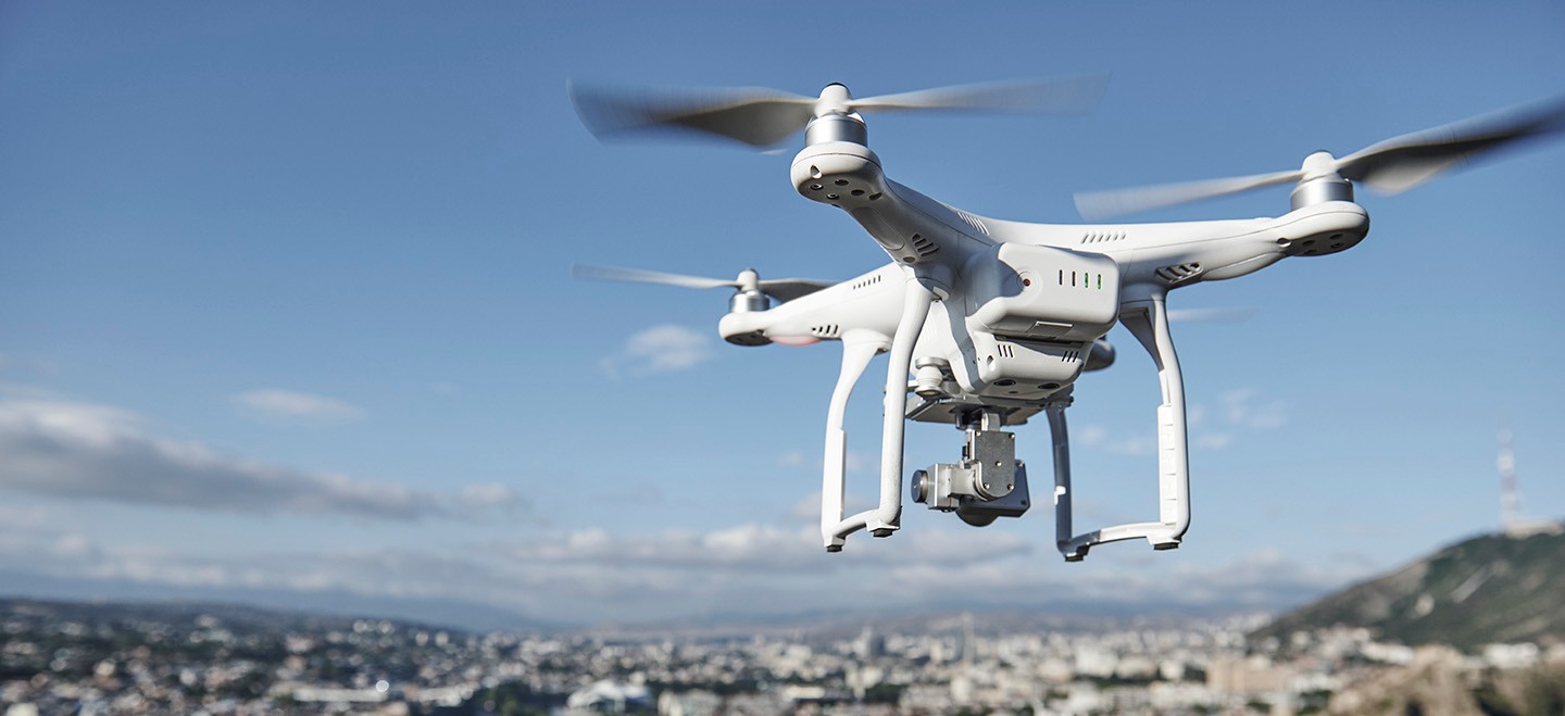 Un dron comercial sobrevuela una ciudad. 