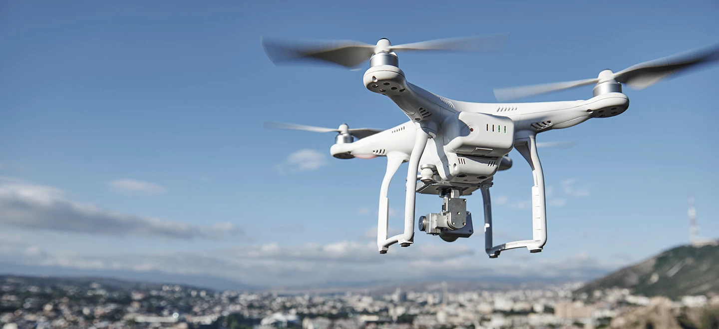 A commercial drone flies over a city. 