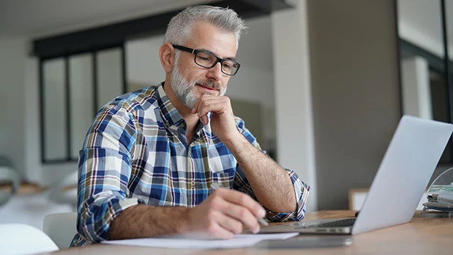 A student taking notes in an on-demand course​.