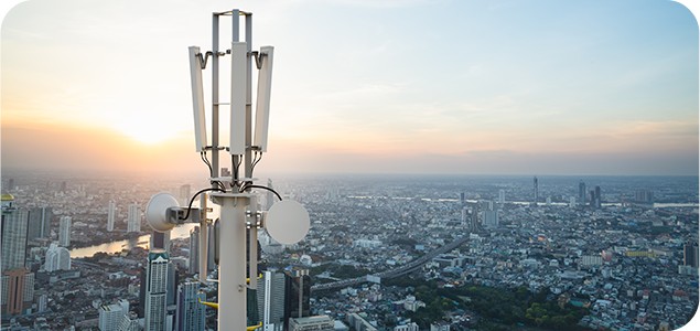 Cellular communications tower overlooking a cityscape