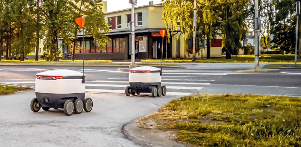 Autonomous delivery robots crossing a street.