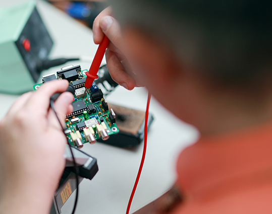 IT Programmer working with LabVIEW on desktop computer