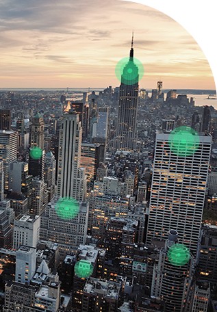 숫가의 도시 스카이라인이 일출 배경에 펼쳐지고, 녹색 무선 네트워크 신호 비콘들이 중첩되어 표시된 모습