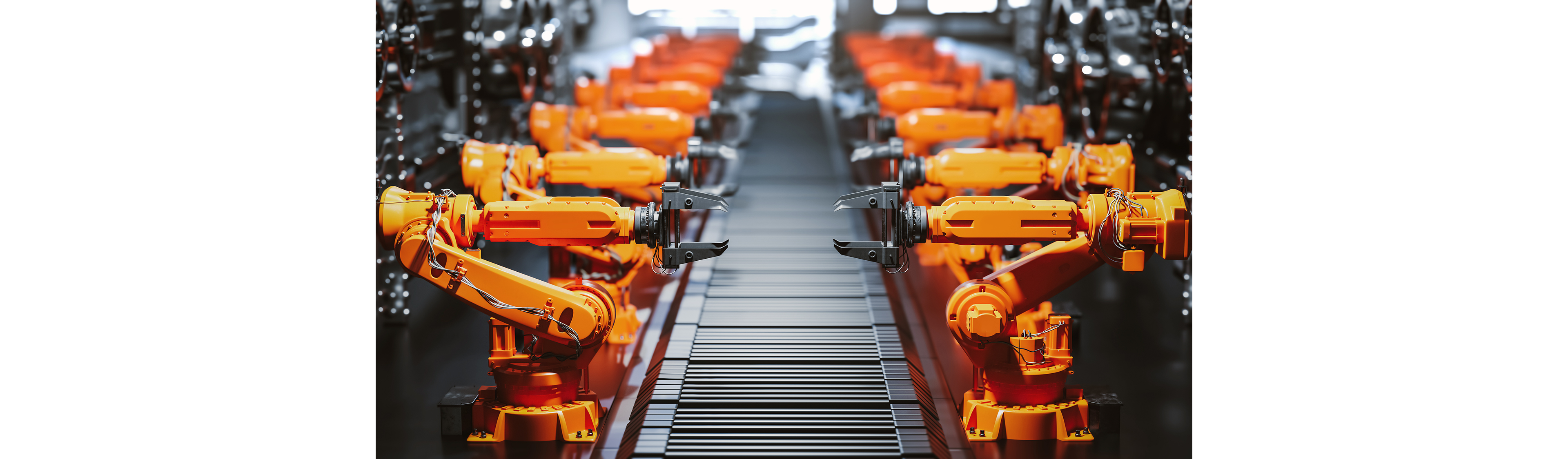 Reihe von orangefarbenen industriellen Roboterarmen, die entlang einer Fabrikmontagelinie arbeiten.