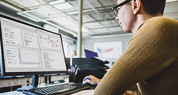 Mann, der an einem Computer an LabVIEW-Programmcode arbeitet.