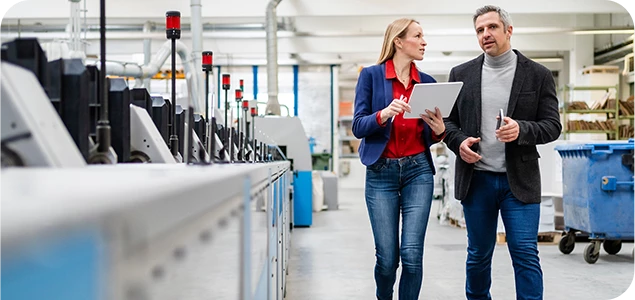 Two engineers walking along production floor  