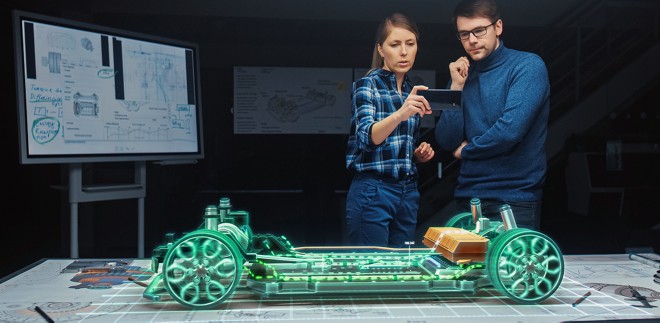 two engineers evaluate an augmented reality image of vehicle components