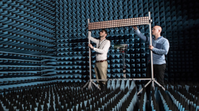 Engineers conducting standard-compliant wireless signal testing in an anechoic chamber using advanced RF measurement instrumentation.