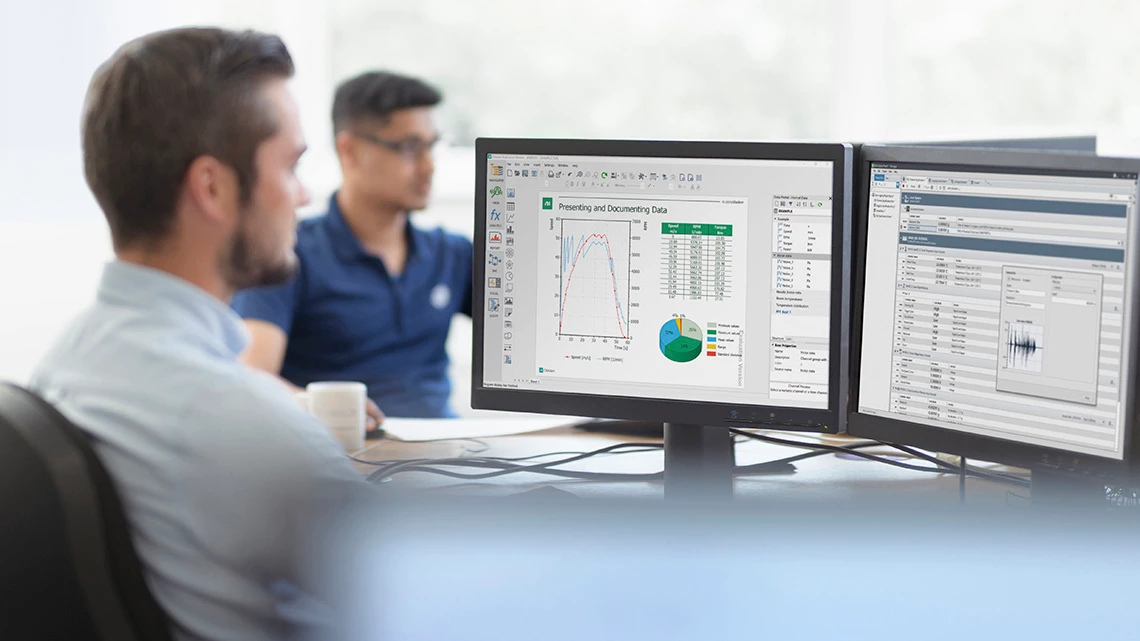 Workplace showing two men using NI software with data from NI hardware.