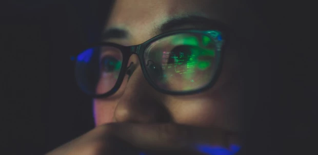 Data from a computer monitor is reflected in a validation engineer's glasses.