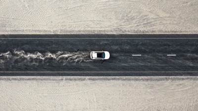 埃っぽい道路を走る車の空撮