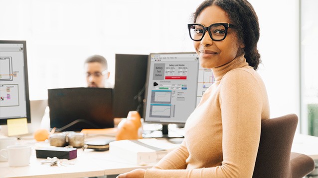 Una mujer está creando una aplicación de LabVIEW en la PC de escritorio de su oficina.