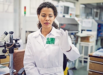 A woman wearing a white shirt performs a test on a 5G semiconductor