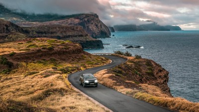 Auto fährt auf der Straße neben einer Klippe