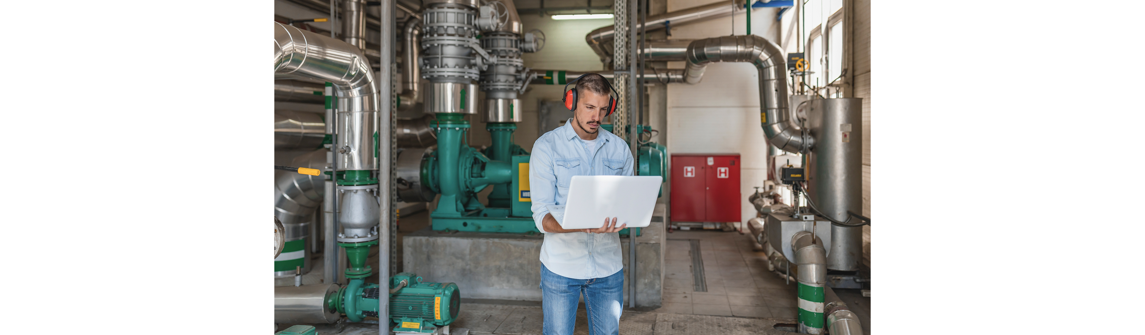 L’ingénieur de maintenance surveille le système d’ébullition de l’installation de chauffage. Il se tient près du générateur d'alimentation avec des écouteurs de protection.