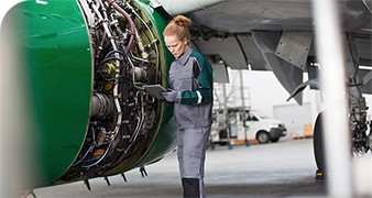 an engineer holding a tablet monitors the heath of a jet engine