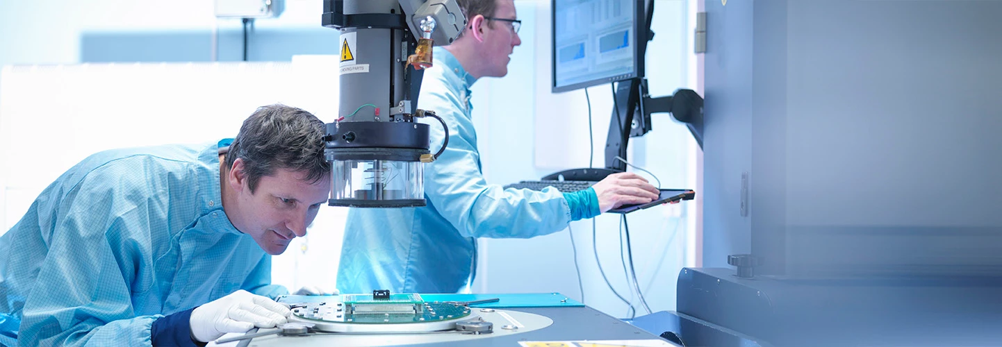 men examining circuit board in lab