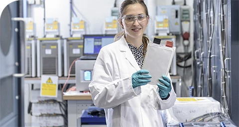 Ingeniero de pruebas en un laboratorio de pruebas de baterías, sostiene una celda estilo sobre