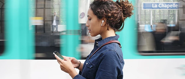 woman using a wireless headphones and working on her phone