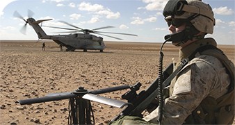 Soldier in the desert with a helicopter in the background