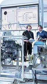 two engineers in front of hardware used for hil simulation