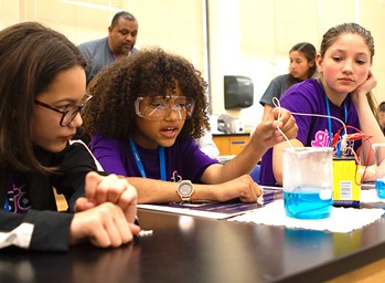 Girls conducting an experiment in science class