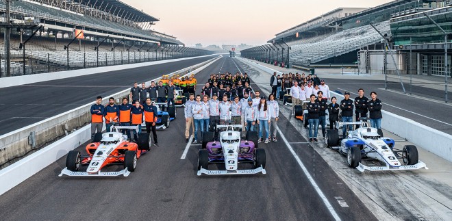 Teams stand with their autonomous race cars on the track at the Indy Autonomous Challenge