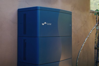 Close-up of a Lunar Energy home battery unit mounted on a stucco wall.​