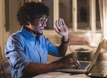 An engineering student signs on to class remotely from his laptop at home.