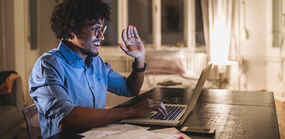 An engineering student signs on to class remotely from his laptop at home.