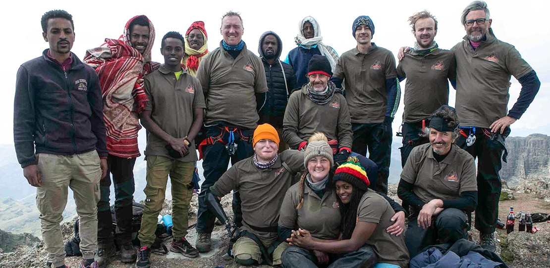 A team of engineers and hikers with mobility impairments pose at the top of Ras Dashen, Ethiopia