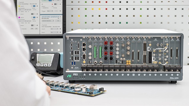PXI modular test system on a lab bench with a circuit board in the foreground