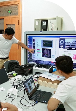 Tecnológico de Monterrey engineering students in a hands-on lab looking at a large screen with engineering concepts displayed