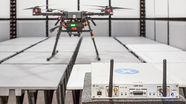 A drone rests on a table during a test with a COTS USRP device