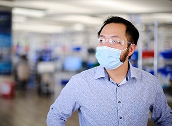 David Weng, lead developer at Velentium, stands on the production floor wearing a mask.