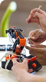 Students operating a robotic arm