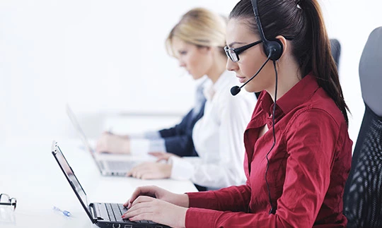 Women working on laptops helping customers over the phone